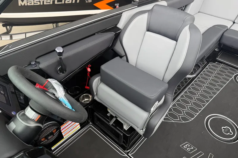 Slide: The Image of 2025 MasterCraft NXT23 boat interior with modern steering wheel and comfortable seating. - 6