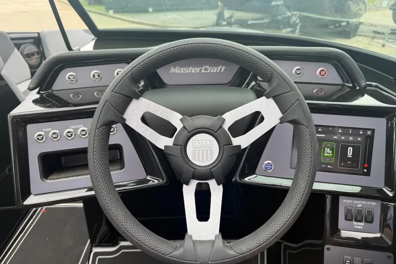 Slide: The Image of Steering wheel and dashboard of 2025 MasterCraft NXT23 boat, featuring modern controls and display. - 8