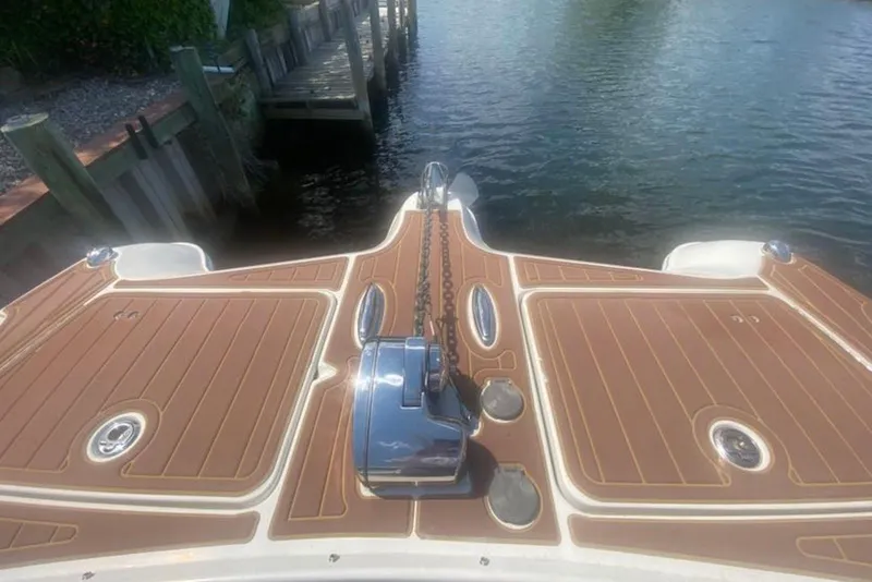 Slide: The Image of 2017 World Cat 320 DC boat deck with anchor chain, docked by water. - 1