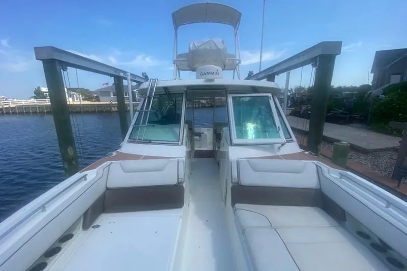 Slide: The Image of 2017 World Cat 320 DC boat docked, featuring spacious seating and modern design. - 2
