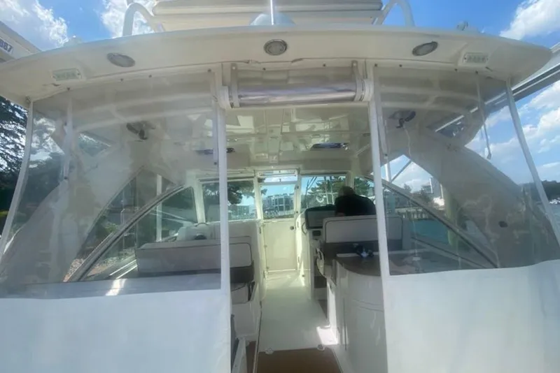 Slide: The Image of 2017 World Cat 320 DC boat interior with seating and helm, under a clear blue sky. - 3