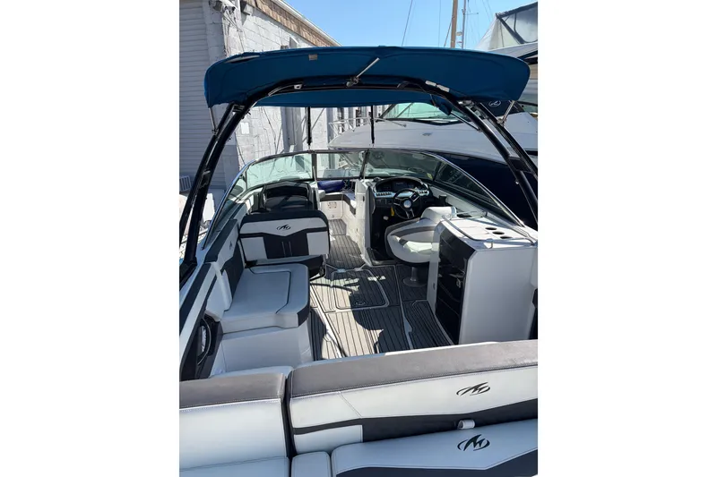 Slide: The Image of 2019 Monterey 278SS Super Sport boat interior with seating and helm, docked under blue canopy. - 16