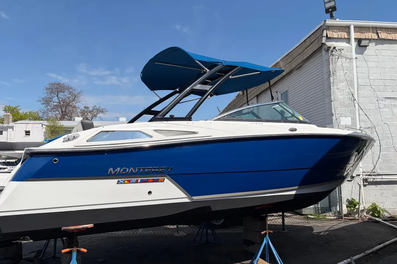 Slide: The Image of 2019 Monterey 278SS Super Sport boat with blue hull and canopy, docked outdoors. - 8