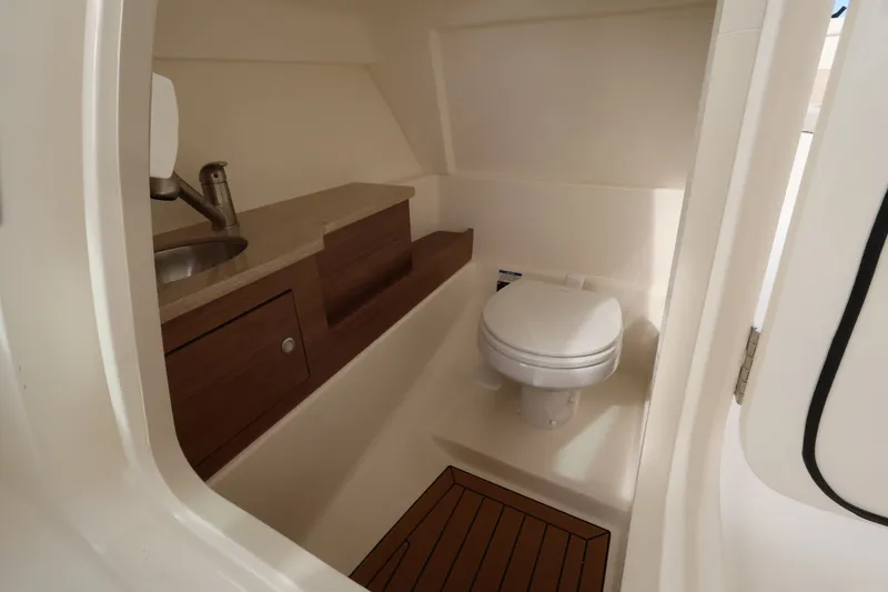 Slide: The Image of Interior of a modern boat cabin with a toilet, sink, and wood accents. - 26
