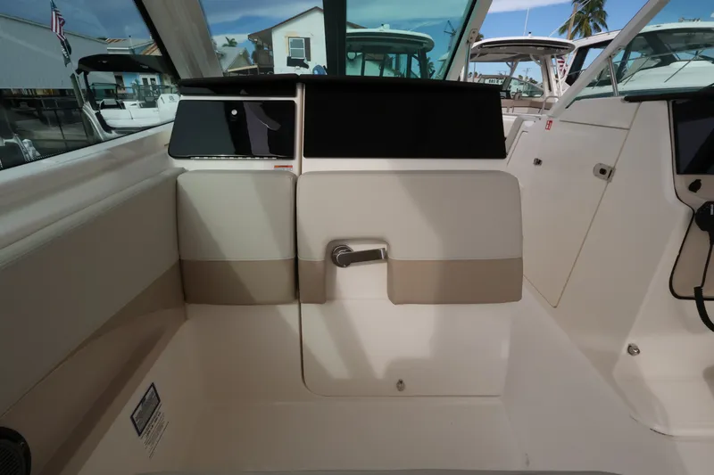 Slide: The Image of Interior view of a Boston Whaler 280 Vantage with beige and white interior and helm console. - 24