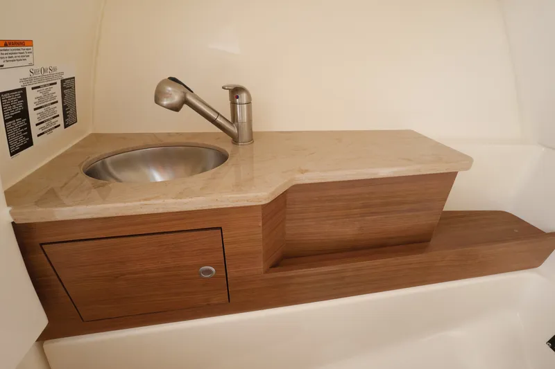 Slide: The Image of A sleek sink with a faucet on a wooden countertop, accompanied by a small cabinet. - 27