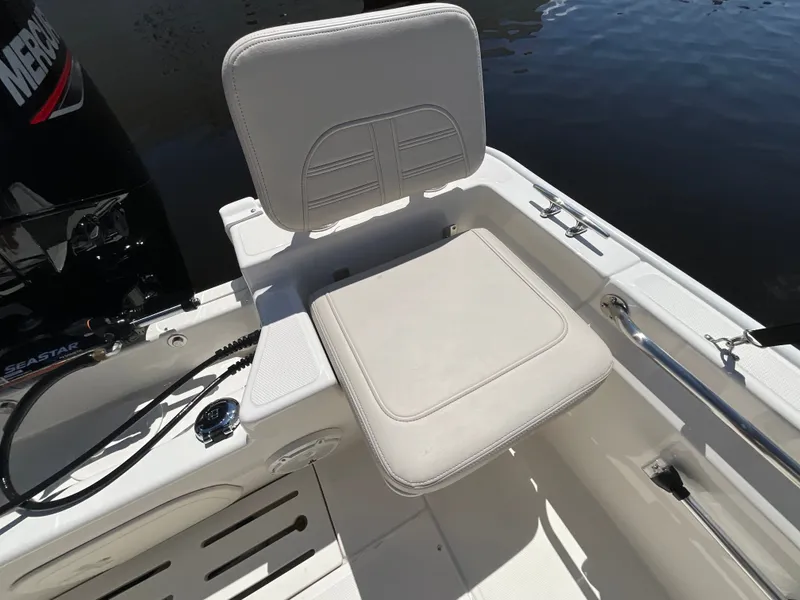 Slide: The Image of A white seat on a Boston Whaler 170 Montauk boat, with an engine in the background. - 19
