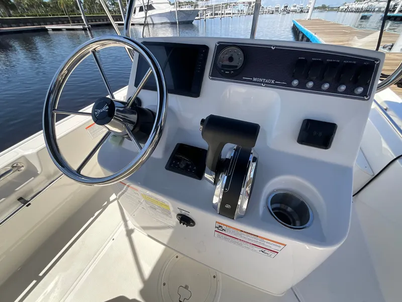 Slide: The Image of The image shows the helm of a Boston Whaler 170 Montauk boat with a steering wheel and instruments. - 17