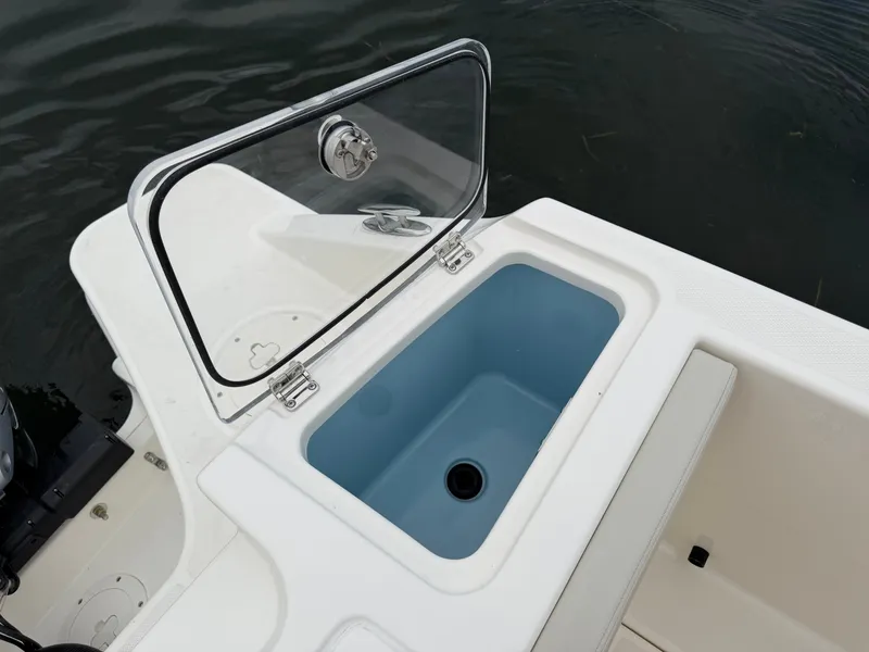 Slide: The Image of An open storage compartment on a Boston Whaler 280 Vantage boat, floating on calm water. - 32