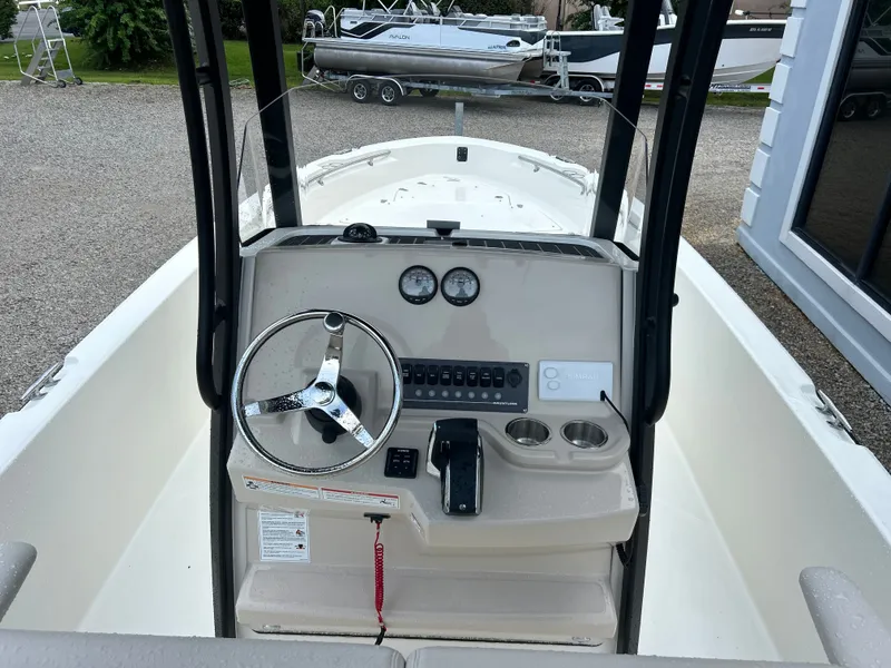 Slide: The Image of The image shows the helm of a 2027 Boston Whaler 250 Dauntless with steering wheel and gauges. - 12