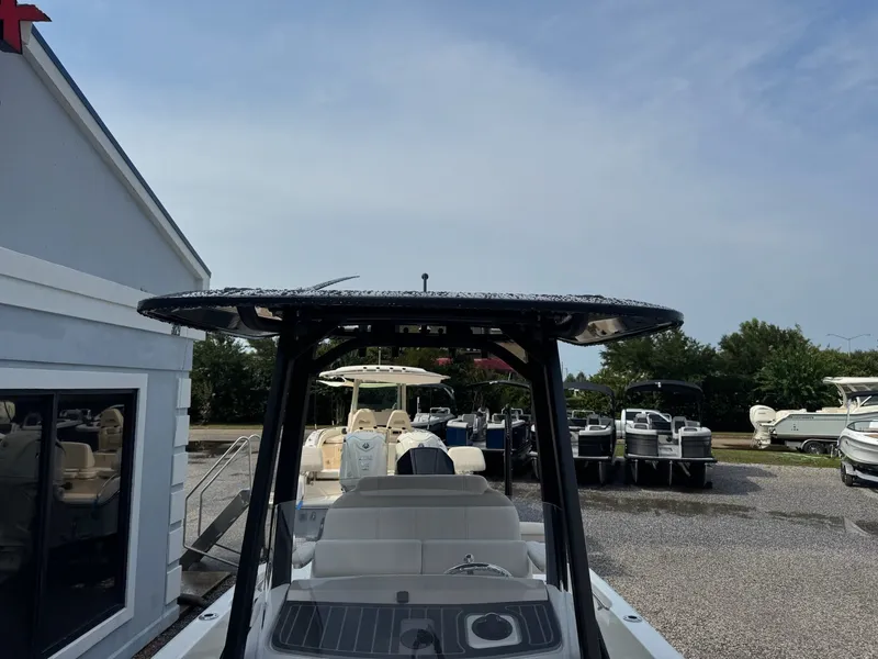 Slide: The Image of A 2027 Boston Whaler 250 Dauntless is parked on a gravel lot. Other boats are visible in the background. - 23