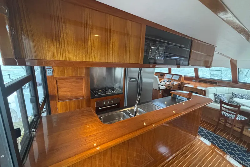 Slide: The Image of Luxurious 2006 Lidgard Custom Catamaran interior with sleek wood finishes and modern kitchen amenities. - 18