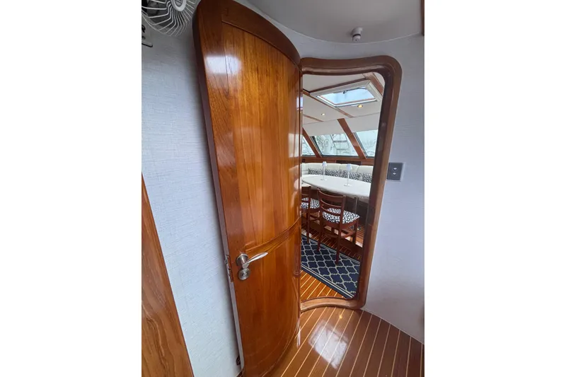 Slide: The Image of Interior view of 2006 Lidgard Custom Catamaran with wooden door and dining area. - 23