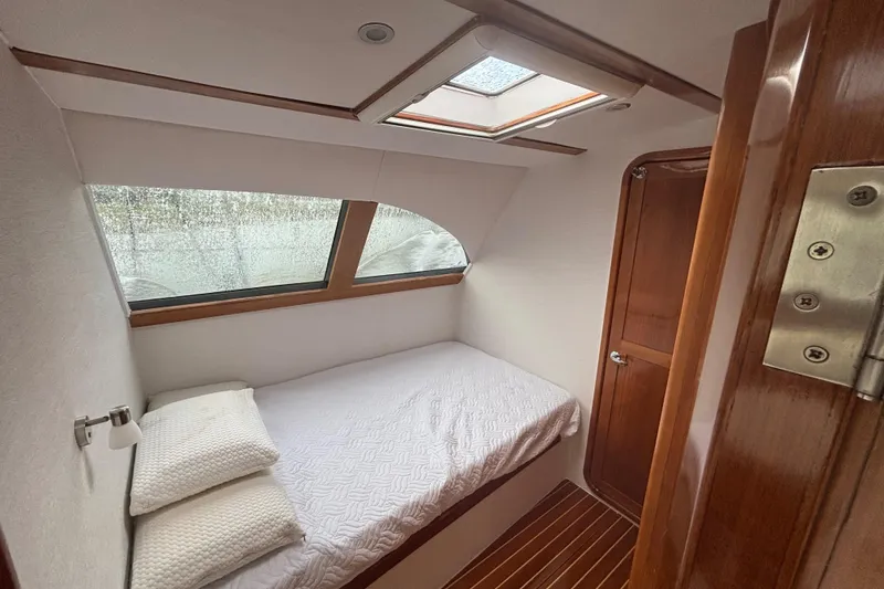Slide: The Image of Cozy cabin interior of 2006 Lidgard Custom Catamaran with bed, window, and wooden accents. - 24
