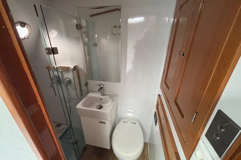 Slide: The Image of Bathroom interior of 2006 Lidgard Custom Catamaran with shower, sink, and wooden cabinets. - 25