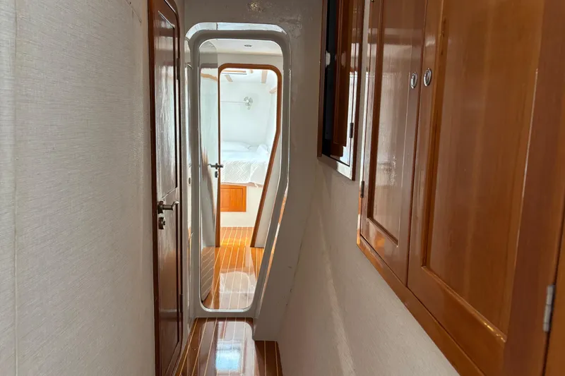 Slide: The Image of Narrow hallway inside 2006 Lidgard Custom Catamaran, featuring wooden cabinets and polished flooring. - 26