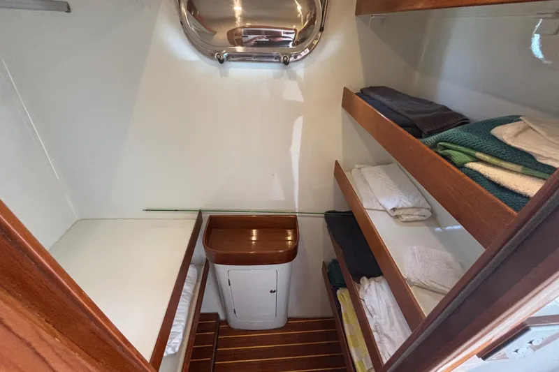 Slide: The Image of Interior of 2006 Lidgard Custom Catamaran with wooden shelves and neatly folded towels. - 27