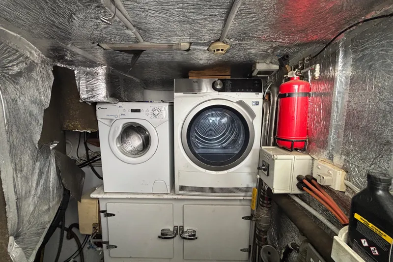 Slide: The Image of Laundry area inside a 2006 Lidgard Custom Catamaran with washer, dryer, and fire extinguisher. - 34
