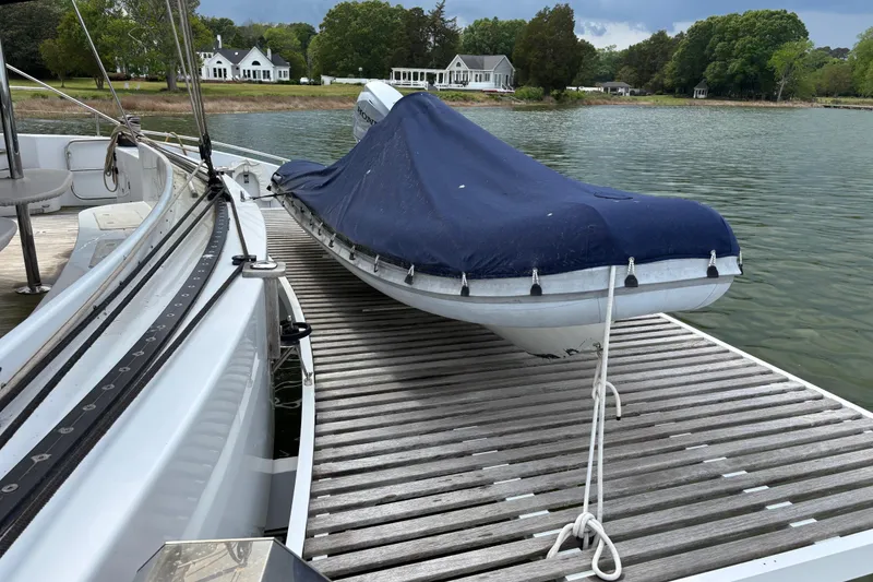 Slide: The Image of 2006 Lidgard Custom Catamaran docked with covered dinghy, scenic waterfront homes in background. - 37