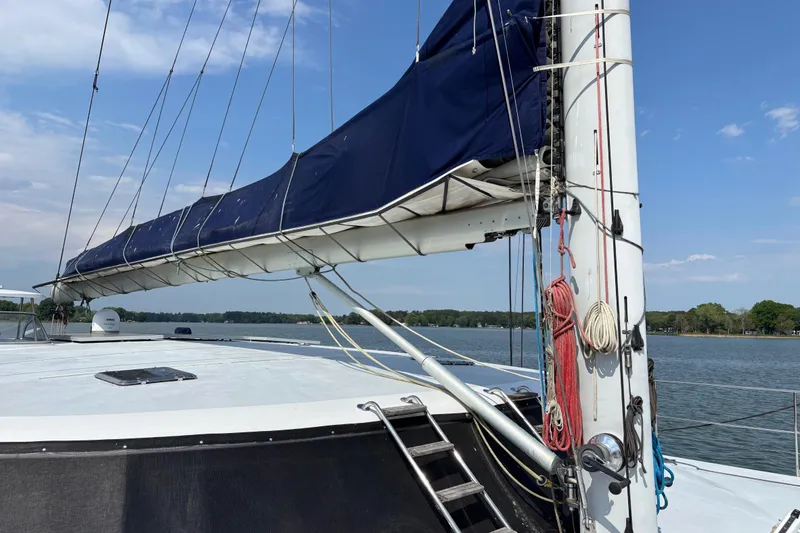 Slide: The Image of 2006 Lidgard Custom Catamaran sailboat on calm water, featuring a blue sail cover. - 7