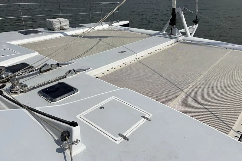 Slide: The Image of 2006 Lidgard Custom Catamaran deck with netting and hatches, anchored on calm water. - 8