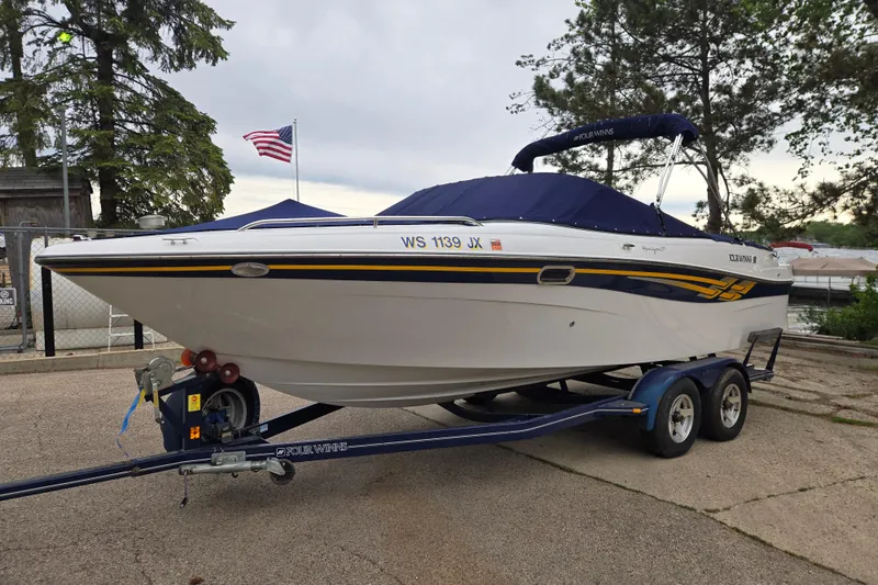 Slide: The Image of 2001 Four Winns 230 Horizon boat on trailer, parked near trees and American flag. - 1