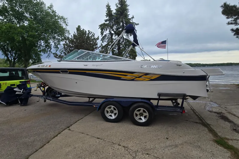 Slide: The Image of 2001 Four Winns 230 Horizon boat on trailer by lakeside with American flag. - 10