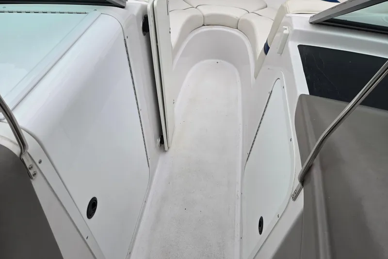Slide: The Image of 2001 Four Winns 230 Horizon boat interior with white seating and walkway. - 14