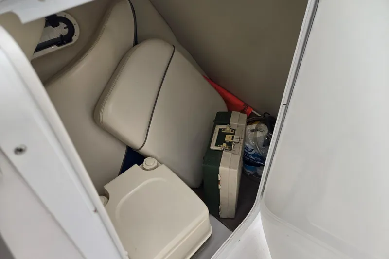 Slide: The Image of Storage compartment in a 2001 Four Winns 230 Horizon boat with seat cushions and supplies. - 15