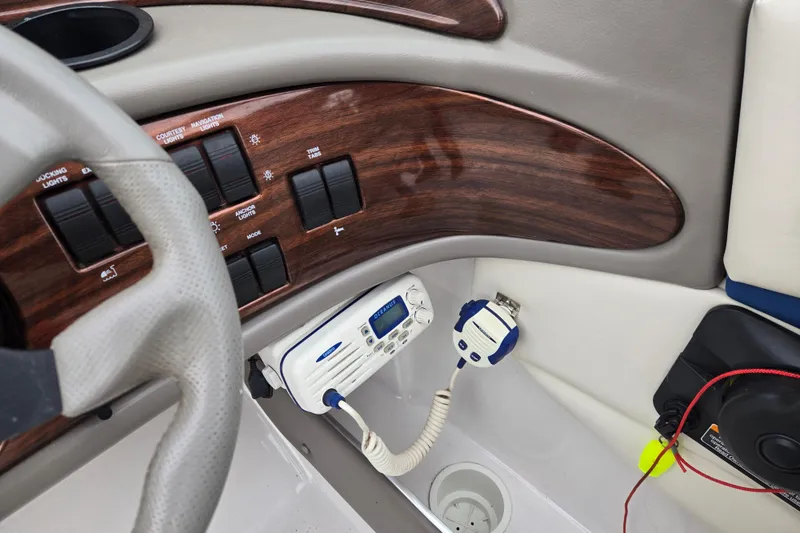 Slide: The Image of 2001 Four Winns 230 Horizon dashboard with wood paneling and marine radio. - 18