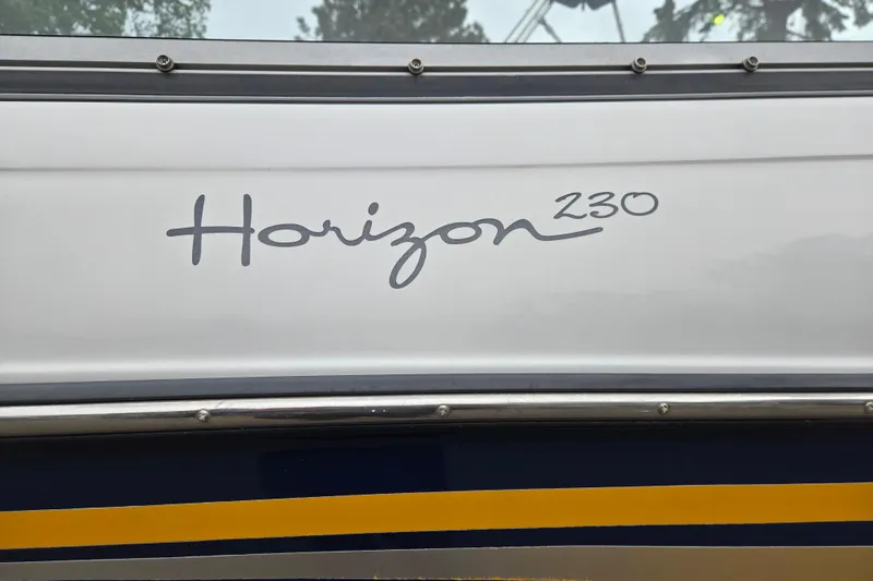 Slide: The Image of 2001 Four Winns 230 Horizon boat logo on white and blue hull. - 26