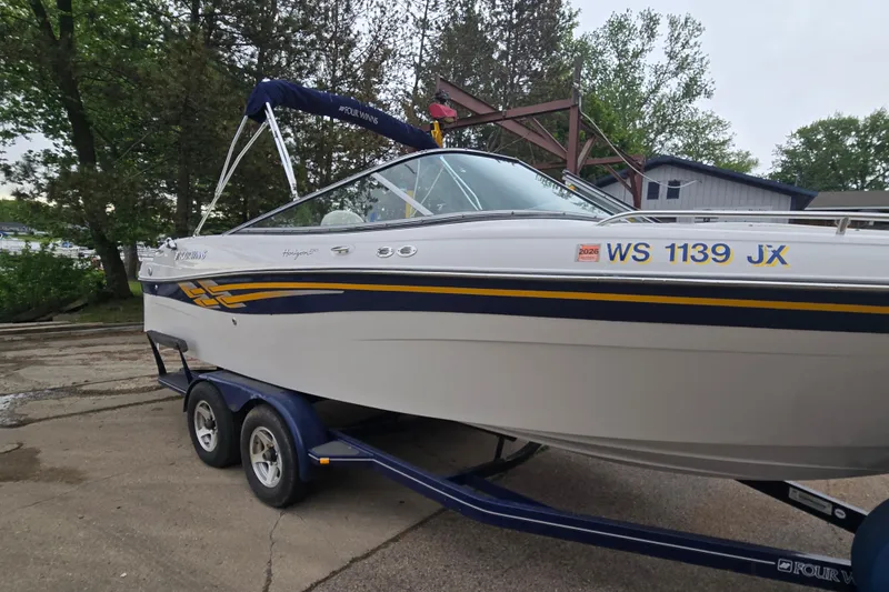 Slide: The Image of 2001 Four Winns 230 Horizon boat on trailer, parked outdoors with trees in background. - 3