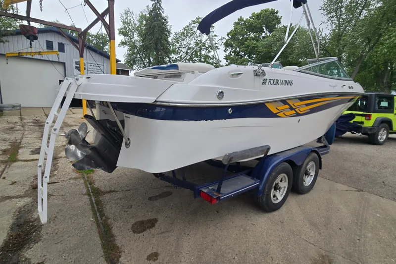 Slide: The Image of 2001 Four Winns 230 Horizon boat on trailer, parked outdoors near a building. - 8