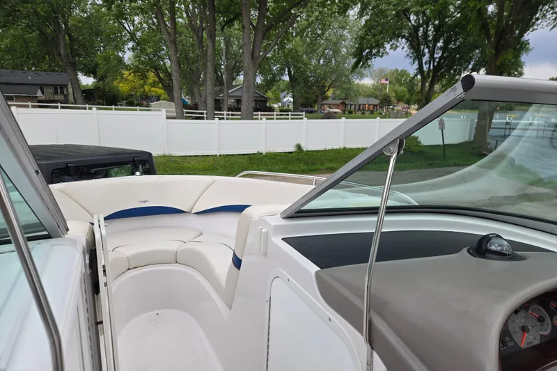 Slide: The Image of 2001 Four Winns 230 Horizon boat interior with white seating and windshield, surrounded by trees. - 9
