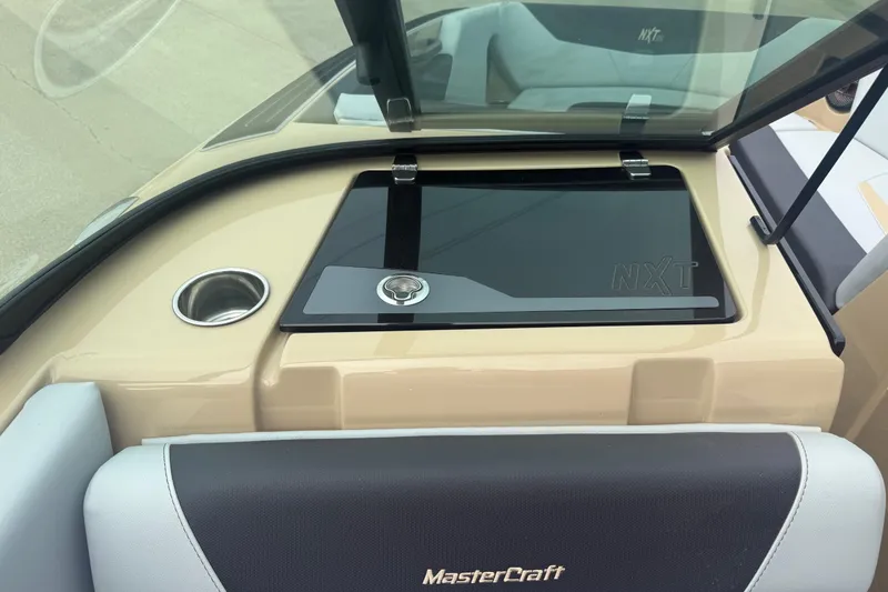 Slide: The Image of 2025 MasterCraft NXT24 boat interior with sleek dashboard and cup holder. - 14