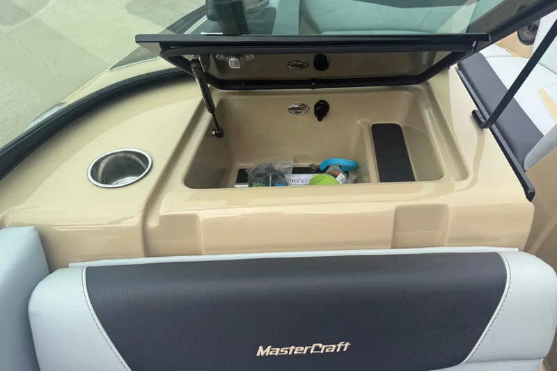 Slide: The Image of 2025 MasterCraft NXT24 boat storage compartment with cup holder and accessories. - 15