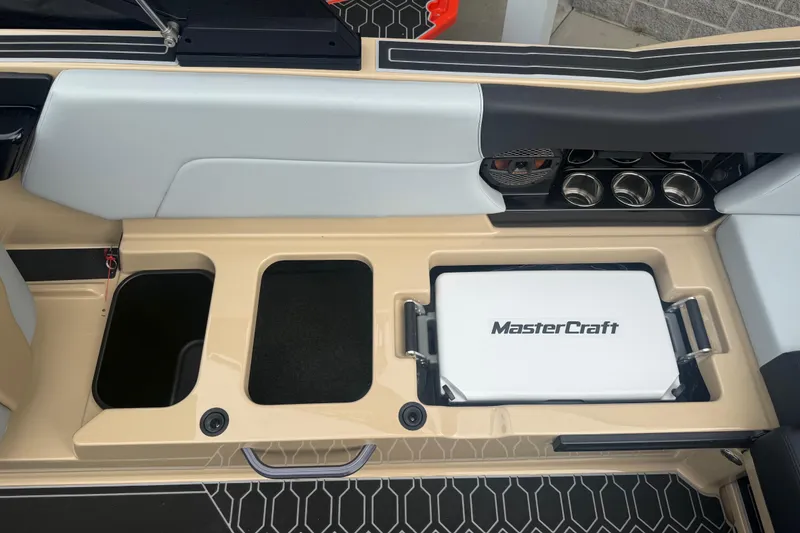 Slide: The Image of 2025 MasterCraft NXT24 boat interior with storage compartments and branded cooler. - 19