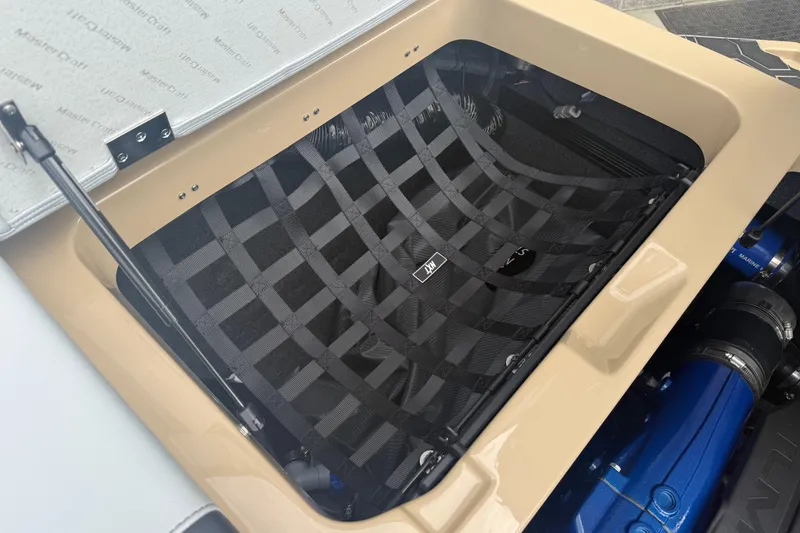 Slide: The Image of 2025 MasterCraft NXT24 engine compartment with protective netting and visible blue engine components. - 27