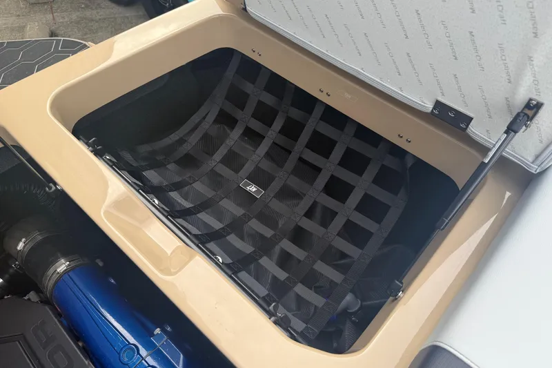 Slide: The Image of Storage compartment in 2025 MasterCraft NXT24 boat with netting and hydraulic lift. - 28