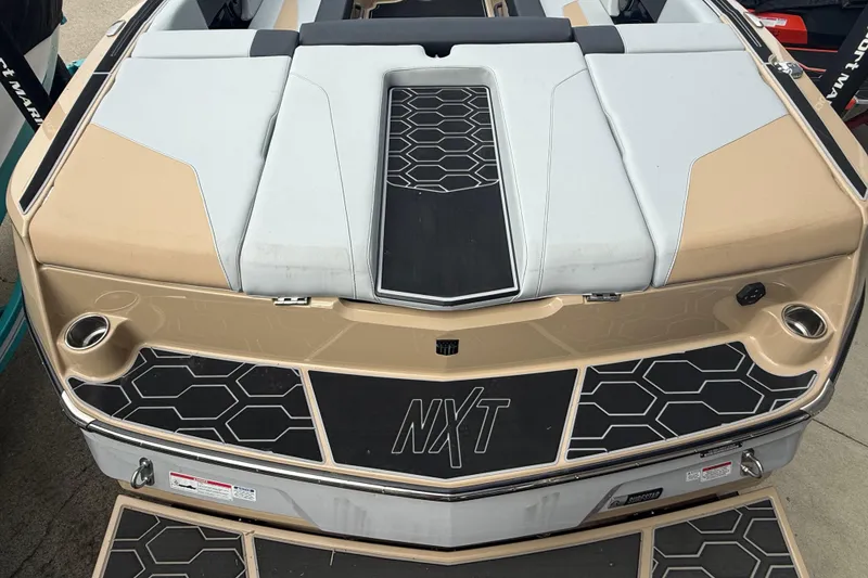 Slide: The Image of 2025 MasterCraft NXT24 boat with beige and black hexagonal design accents. - 29