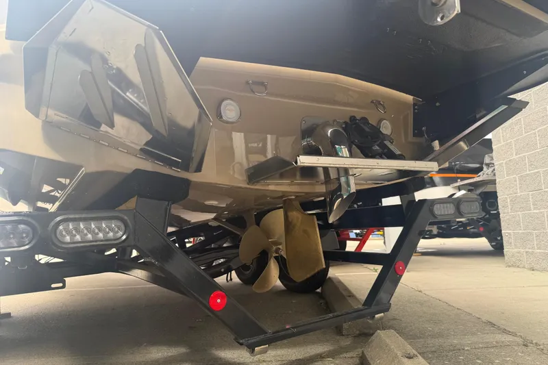 Slide: The Image of 2025 MasterCraft NXT24 boat underside showing propeller and trailer details. - 32
