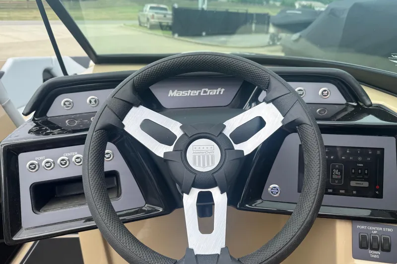 Slide: The Image of Steering wheel and dashboard of 2025 MasterCraft NXT24 boat, featuring modern controls and displays. - 8