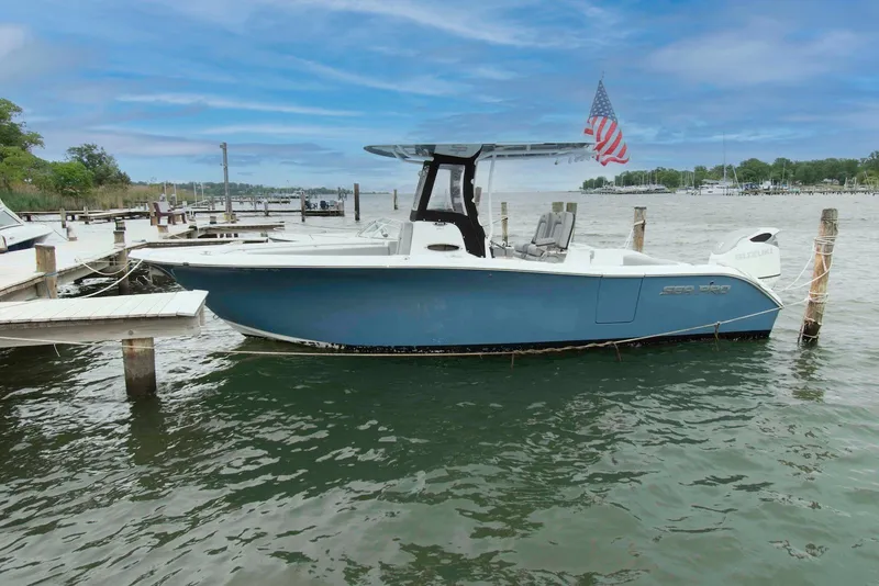 The Image of 2021 Sea Pro 259 Center Console boat docked, featuring sleek design and American flag. - 0