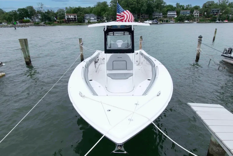 Slide: The Image of 2021 Sea Pro 259 Center Console boat docked, featuring sleek design and American flag. - 3
