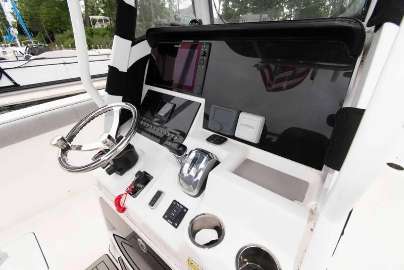 Slide: The Image of 2021 Sea Pro 259 Center Console boat dashboard with steering wheel and controls. - 6