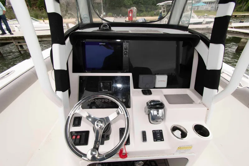 Slide: The Image of 2021 Sea Pro 259 Center Console boat dashboard with steering wheel and navigation controls. - 7