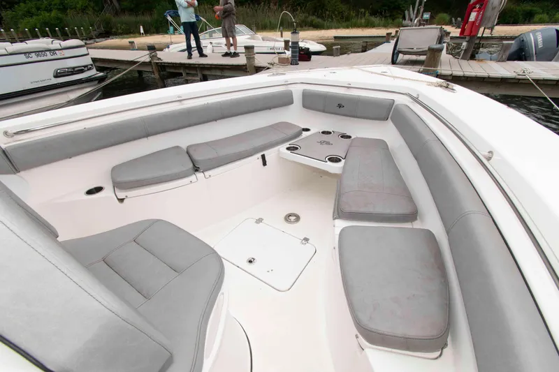 Slide: The Image of 2021 Sea Pro 259 Center Console boat with spacious seating and cup holders at dock. - 8