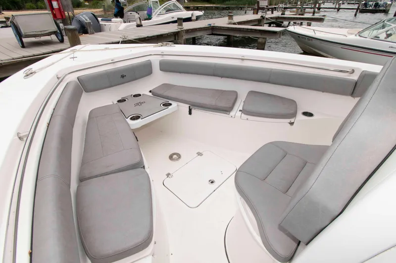 Slide: The Image of 2021 Sea Pro 259 Center Console boat with spacious seating and cup holders at dock. - 9
