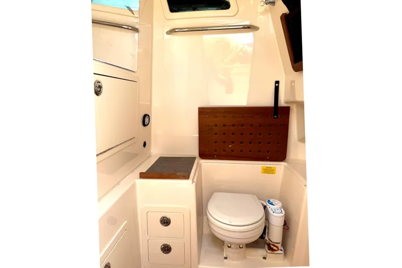 Slide: The Image of 2018 Grady-White Canyon 306 boat interior with compact marine toilet and storage. - 26