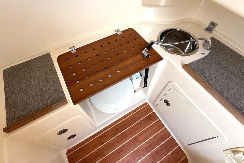 Slide: The Image of 2018 Grady-White Canyon 306 boat interior with sink, wooden accents, and storage. - 27